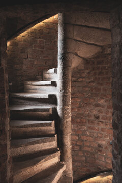 People walk up and down the spiral staircase inside White Tower in Hradec Kralove. The old stone walls and lighting create a unique atmosphere. It is a popular place for visitors.