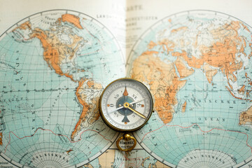 Vintage brass compass on an old geographic map close up. Antique navigation instrument for travel, exploration, geography and discovery concept. Adventure, tourism, cartography and orientation theme. © Tryfonov