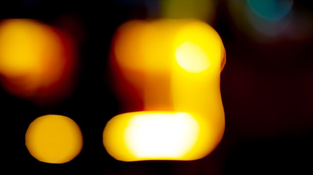 Abstract golden bokeh lights glowing against a dark night background featuring soft warm orange circular shapes and blurred artistic textures
