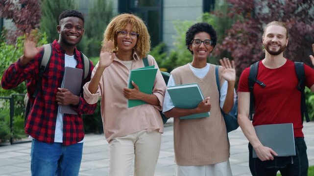 Group of happy multiracial students four diversity classmates greeting hello hi looking at camera smiling cheerful together in city outside university campus college academy studying learning course