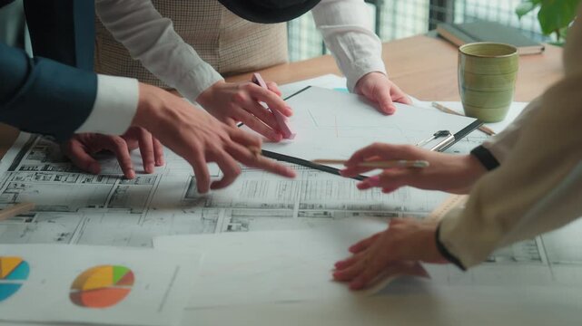 Unrecognizable business team working with blueprint diagram documents planning project startup together in office teamwork three workers discussion architecture draw building plan multiracial group