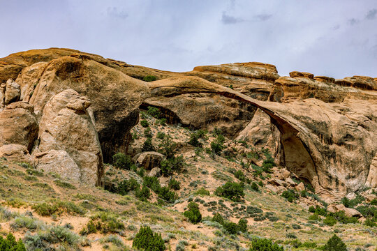 Landscape Arch's thin sandstone span is seen from a side angle along the ridge in Devils Garden, Arches National Park.
