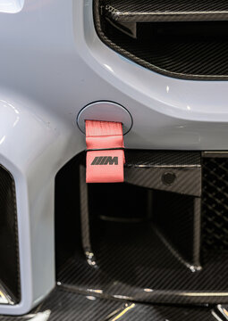 Gothenburg, Sweden - May 30 2026: Red fabric tow strap on carbon fiber racing bumper.