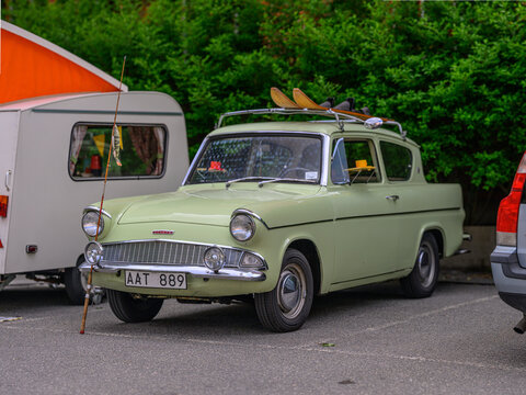 Gothenburg, Sweden - May 30 2026: Pale green Ford Anglia estate parked with fishing gear at roadside.