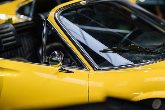 Gothenburg, Sweden - May 30 2026: Close detail of yellow Ferrari Dino mirror and windshield.