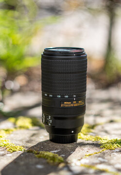 Gothenburg, Sweden - April 21 2024: telephoto camera lens standing upright on stone surface in sunlight.