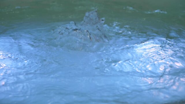 Close-up of bubbling water texture in a hot tub with blue underwater illumination.