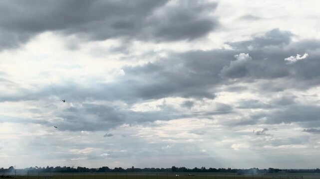Precision aerobatic aircraft complete a perfect loop with contrails over white clouds.
