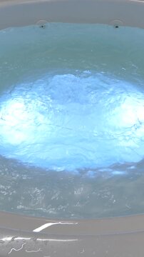 Round hot tub jacuzzi with bubbling blue water and internal illumination at night.