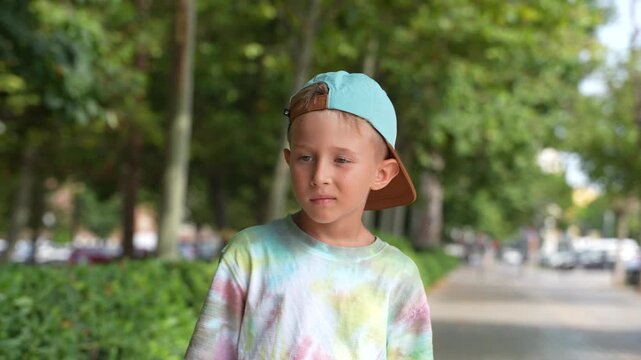 Cute Little Boy Wearing Backward Cap Standing in Summer Park Outdoors