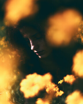 a girl observed a flower in a serene state, with the blurred depths of the fields