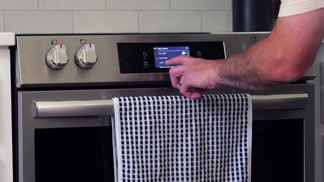 Man setting digital clock time on kitchen microwave stove appliances, representing changing clocks - daylight savings time, spring forward, fall back