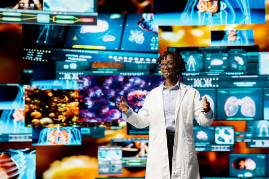 A biomedical specialist discusses pathogens and antiviral strategies during a medical conference while a scientist presents genome data and compares infection models on screen to an audience.