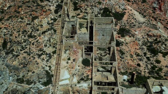 Flying over the Old Slufur Mines Thiorichia, Milos, Greece, moving to an overhead shot to show the outline. Shot on a 4k at 60 fps on a DJI Mini 3 Pro in D-Log Film Colorgraded