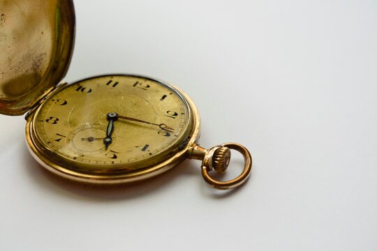 Open antique gold pocket watch dial with blued hands