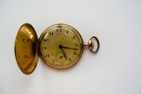 Antique gold pocket watch dial and crown close-up from above
