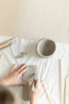 Woman potter meticulously shaping clay in a studio setting