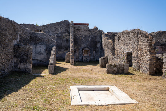 Ancient Roman house ruins with a central impluvium at the archaeological site of Pompeii
