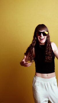 Young energetic woman dancing wearing funky sunglasses