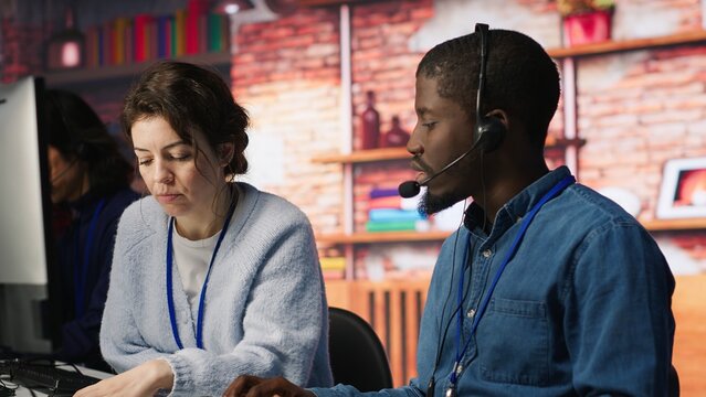 A call center manager supervises an agent providing step-by-step guidance and technical support to customers while overseeing the employee's work and solutions.