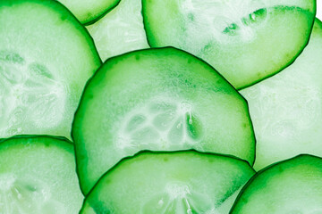 Sliced cucumbers arranged in overlapping pattern, vibrant green slices, crisp texture, neutral white background, clean minimalistic style, natural beauty and freshness, appetizing presentation © Mister