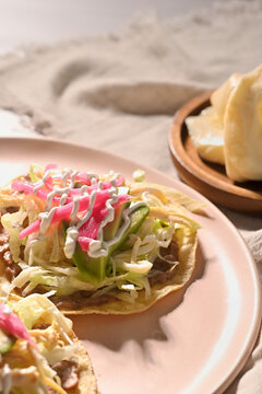 Chicken tostadas. Delicious homemade Mexican food with quesillo cheese on the background. Direct flash light
