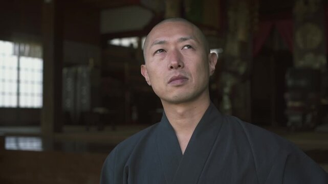 Asian monk opening a sliding door and walking inside a traditional buddhist temple in Japan