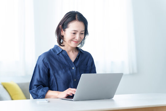 自宅でデスクワークをする中高年女性