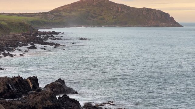 The Bluff rises out of the ocean at dusk on the Fleurieu Peninsula in South Australia in 60FPS 4K video footage