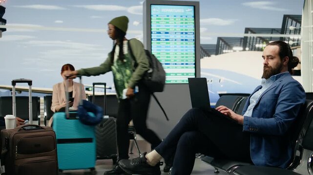 Businessman uses a laptop and checks his smartphone while waiting at the airport for an international flight during a corporate business trip and work delegation at company headquarters.