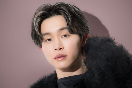 秋冬のヘアスタイルをイメージした日本人男性 のハイライトヘアカラー、ヘアセットやメンズ美容ポートレートのカメラ目線クローズアップ