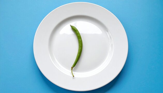 Minimal White Plate with Single Green Bean on Blue Background