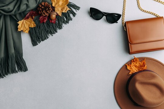 Autumn flat lay of fashion accessories and fall clothing style on gray background