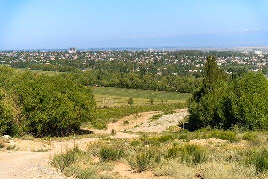 Dirt road and dry riverbed leading to Karakol, Kyrgyzstan in Summer