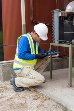Hvac technician performing scheduled maintenance on an industrial unit