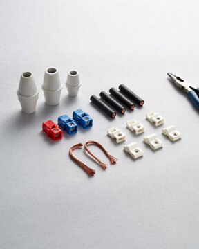 Electrical connectors and wire nuts with pliers on a white background close up.