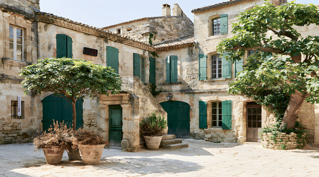 A weathered stone plaza in France glimmers under an unrelenting heatwave, featuring a digital thermometer, shutters tightly closed, parched hanging plants, and a hovering air above delicate paving sla