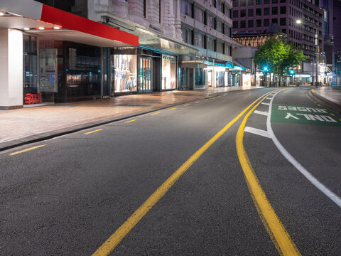 Car background, automotive backplate, central business district road featuring retail shops at night