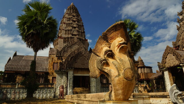 Ancient stone temple with a giant multi-headed Naga snake statue on a sunny day