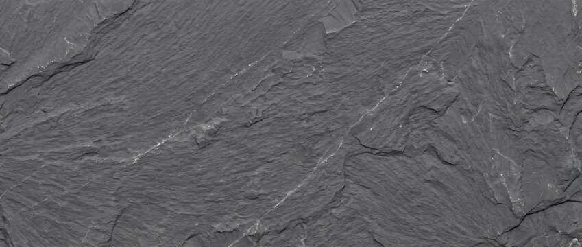 Basalt stone texture featuring rugged dark gray surface with subtle mineral flecks creates an industrial background for modern architectural projects