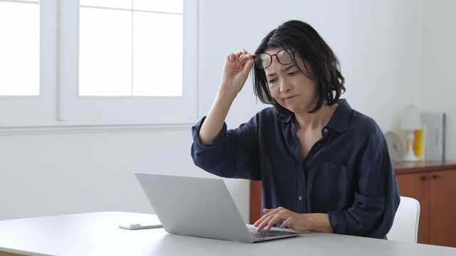 パソコンを使う老眼の中高年女性