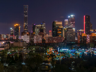 Fototapeta premium Night view of Beijing's CBD skyscrapers and the interplay of light and shadow on park greenery.
