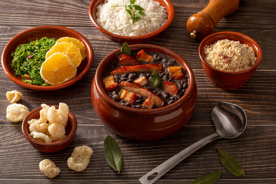 Traditional Brazilian Feijoada Served with Rice, Collard Greens, Farofa, Orange and Pork Cracklings