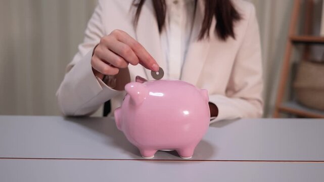 貯金をする女性の手元のクローズアップ