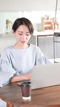 オシャレな明るいオフィスでノートパソコンで仕事をする日本人女性 オフィスワーク・ビジネスシーン縦動画