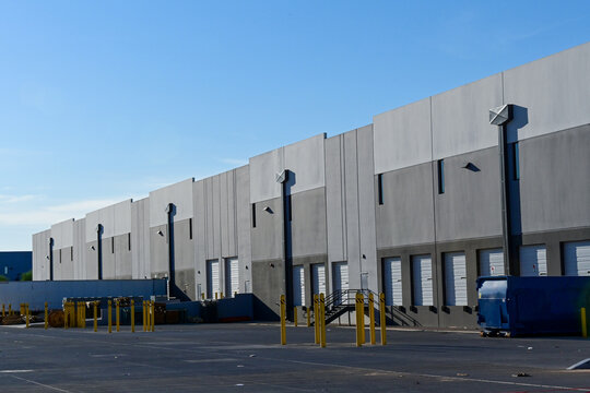 Modern warehouse building with loading docks at an industrial park, illustrating logistics, distribution, commercial real estate, and supply chain operations