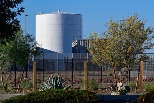 Exterior view of a data center with water storage tank and utility infrastructure, illustrating cloud computing, AI operations, digital infrastructure, and facility support