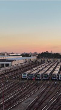 Aerial view of metro trains parked in a large railway depot at sunset