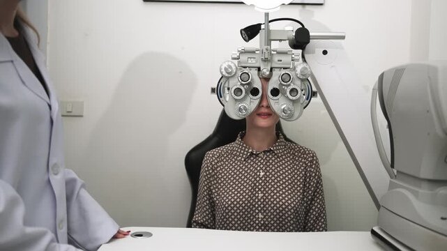 White female patient eye exam with phoropter equipment, vision and eyesight improvement by expert optometrist woman, diagnostic for eyeglasses lens, professional technology services in optical clinic.