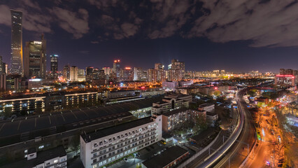 Fototapeta premium The dazzling skyline of Beijing's CBD and the dynamic night view of the railway tracks